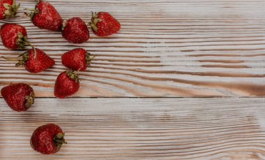 Masanın üzerine taze sulu kırmızı çilekler ve kaliteli kalaslar serpiştirdim. Nane yaprağı. Damlalar ve dökülen sütler. Sebze kesme tahtası. Yüksek kalite fotoğraf