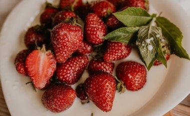 Masanın üzerine taze sulu kırmızı çilekler ve kaliteli kalaslar serpiştirdim. Nane yaprağı. Damlalar ve dökülen sütler. Sebze kesme tahtası. Yüksek kalite fotoğraf