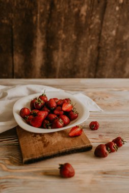 Masanın üzerine taze sulu kırmızı çilekler ve kaliteli kalaslar serpiştirdim. Nane yaprağı. Damlalar ve dökülen sütler. Sebze kesme tahtası. Yüksek kalite fotoğraf