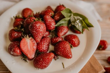 Masanın üzerine taze sulu kırmızı çilekler ve kaliteli kalaslar serpiştirdim. Nane yaprağı. Damlalar ve dökülen sütler. Sebze kesme tahtası. Yüksek kalite fotoğraf
