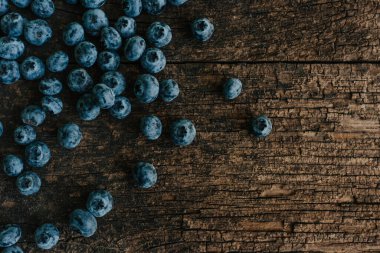 Mavi taze yaban mersini eski kahverengi ahşap çatlamış bir masaya saçılmış..