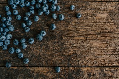 Mavi taze yaban mersini eski kahverengi ahşap çatlamış bir masaya saçılmış..