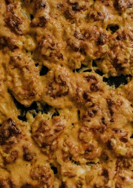 Köfteli pizza. Fırında pişmiş et, siyah metal bir pişirme tepsisinin üzerinde yatıyor. Ağız sulandıran peynir sosu. 