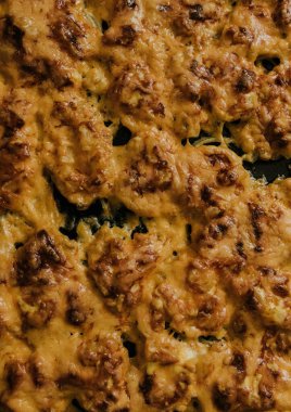 Köfteli pizza. Fırında pişmiş et, siyah metal bir pişirme tepsisinin üzerinde yatıyor. Ağız sulandıran peynir sosu. 