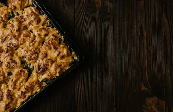 Köfteli pizza. Fırında pişmiş et, siyah metal bir pişirme tepsisinin üzerinde yatıyor. Ağız sulandıran peynir sosu. 