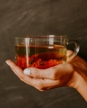 Kadife çiçeğinden çay, kadın elinde portakal takvimi.