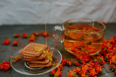 Pişmiş malların üzerindeki bal. Turuncu takvim çiçek çayı.