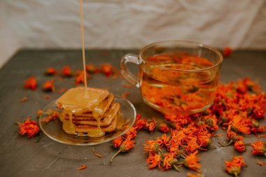 Pişmiş malların üzerindeki bal. Turuncu takvim çiçek çayı.