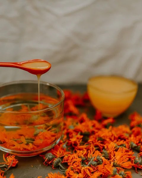 Bir kadının eli kaşıktan fincana bal döker.