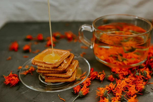 Pişmiş malların üzerindeki bal. Turuncu takvim çiçek çayı.