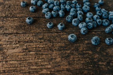 Mavi taze yaban mersini ahşap bir masaya saçılmış..
