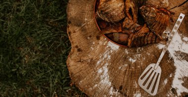 Kızarmış balık sazan balığı, kırık bir kütüğün üzerinde bir tabakta yatıyor.