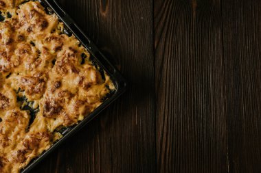 Köfteli pizza. Fırında pişmiş et, siyah metal bir yemek tepsisinin üzerinde yatıyor.