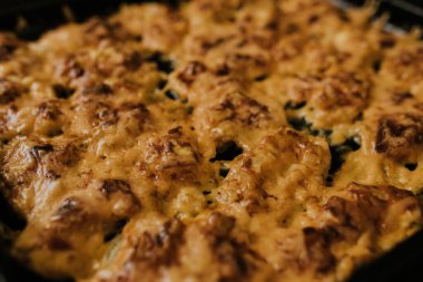 Köfteli pizza. Fırında pişmiş et, siyah metal bir yemek tepsisinin üzerinde yatıyor.