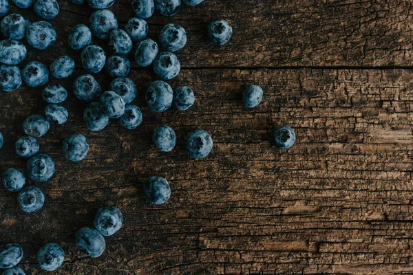 Mavi taze yaban mersini ahşap bir masaya saçılmış..