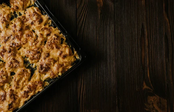 Köfteli pizza. Fırında pişmiş et, siyah metal bir yemek tepsisinin üzerinde yatıyor.