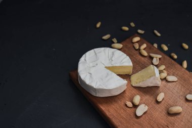 Tahtada küflü ve fındıklı peynirli camembert peyniri.