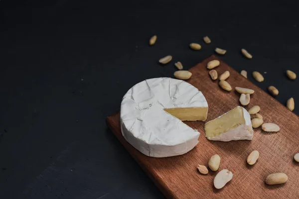 Сыр камамбер с плесенью и орехами на деревянной доске — стоковое фото