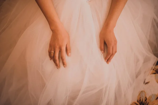 As mãos femininas da noiva de pele clara jazem no vestido de casamento branco — Fotografia de Stock