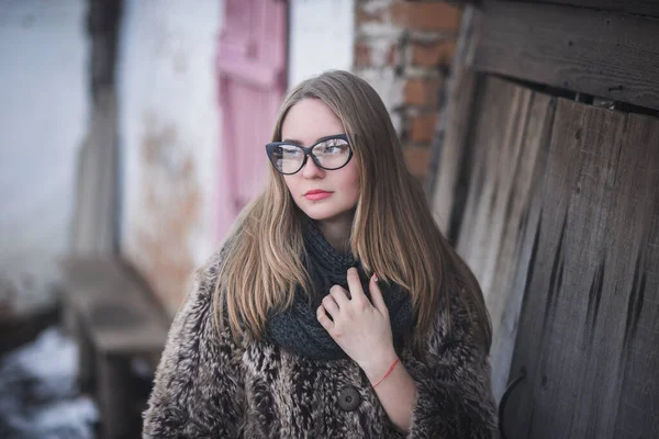 Chica rubia en ojos de gato gafas en un abrigo de piel sintética artificial en invierno —  Fotos de Stock