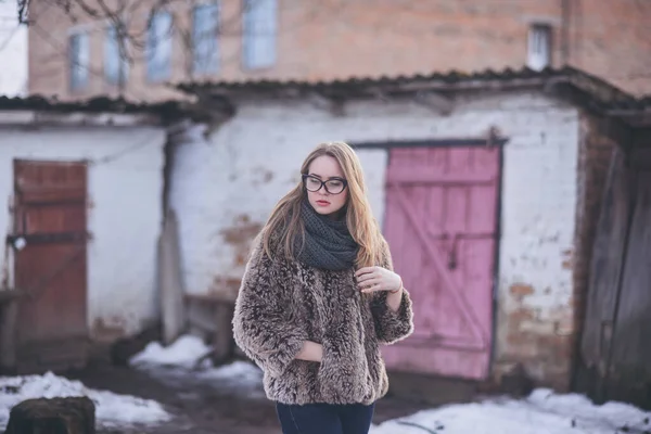 Chica rubia en ojos de gato gafas en un abrigo de piel sintética artificial en invierno —  Fotos de Stock