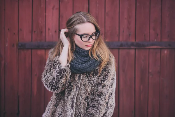 Chica rubia en ojos de gato gafas en un abrigo de piel sintética artificial — Foto de Stock