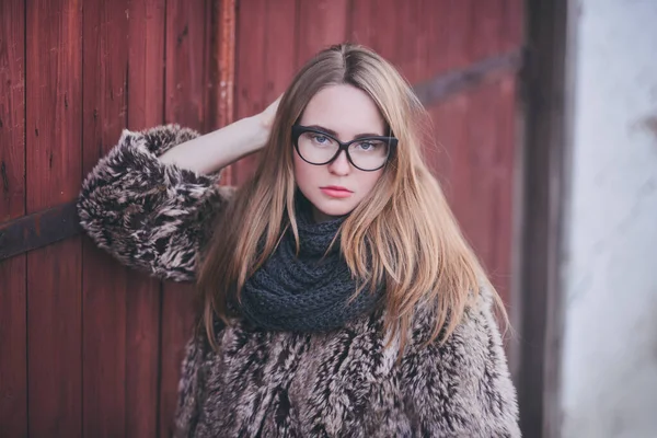 Chica rubia en ojos de gato gafas en un abrigo de piel sintética artificial —  Fotos de Stock
