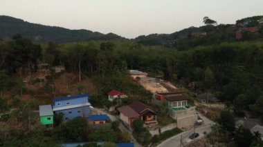 İnsansız hava aracı gün batımından sonra orman ve deniz üzerinde uçuyor.