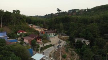 İnsansız hava aracı gün batımından sonra orman ve deniz üzerinde uçuyor.