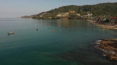 İnsansız hava aracı gün batımından sonra orman ve deniz üzerinde uçuyor.