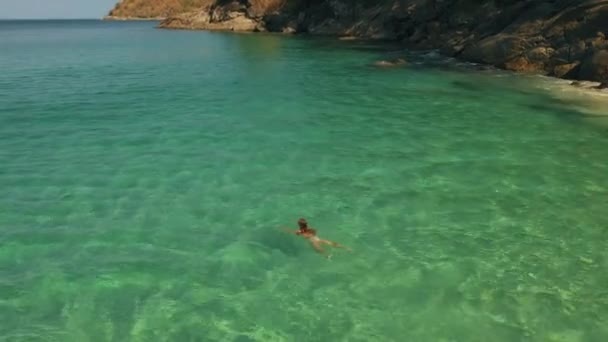 Donna nuota in acqua turchese su una spiaggia selvaggia a Phuket, Thailandia — Video Stock