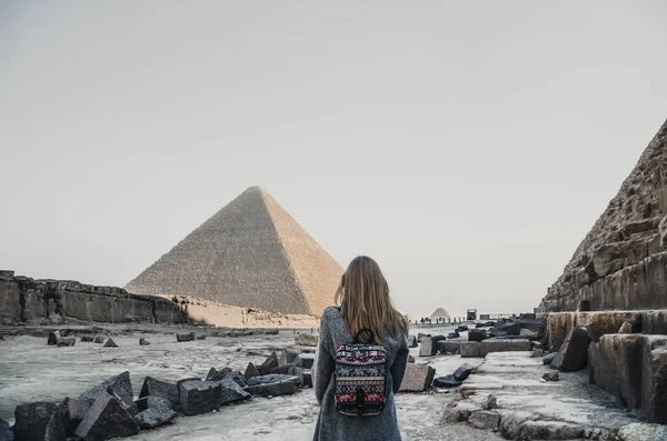 Uma loira europeia caminha perto das pirâmides no deserto no Cairo — Fotografia de Stock