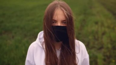 Koruyucu maskeli bir kadın rüzgar salgınında çırpınıyor. Covid-19 Coronavirus. 
