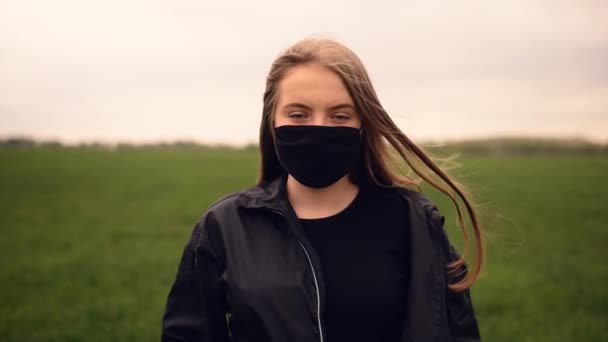 Женщина в защитной маске, трепещущая волосами во время ветровой пандемии ковид-19 Коронавирус — стоковое видео