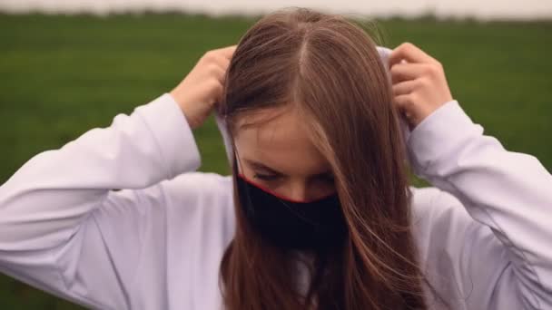 Kobieta w czarnej masce zakłada kaptur pandemiczny kovid-19 Coronavirus — Wideo stockowe