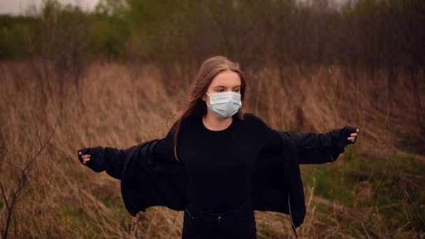 Woman in a mask puts on a jacket at nature pandemic covert-19 Coronavirus — Stock Video