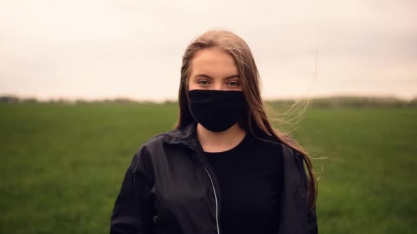 Frau mit schwarzer Maske dreht den Kopf pandemisch kovid-19 Coronavirus — Stockvideo