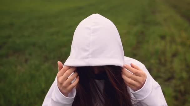 Woman in black mask puts on a hood pandemic kovid-19 Coronavirus — Stock Video