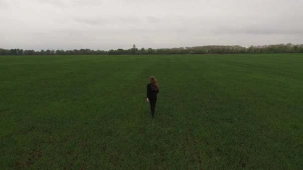 Woman run across a green field in a protective mask from viruses pandemic covid-19 Drone view — Stock Video