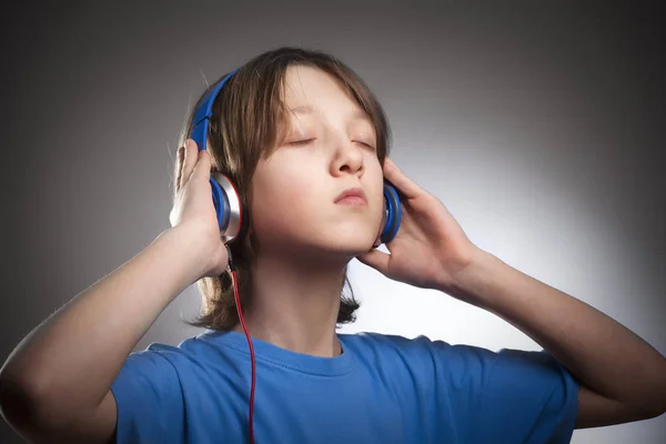 Pojke lyssnar på musik i hörlurar. — Stockfoto