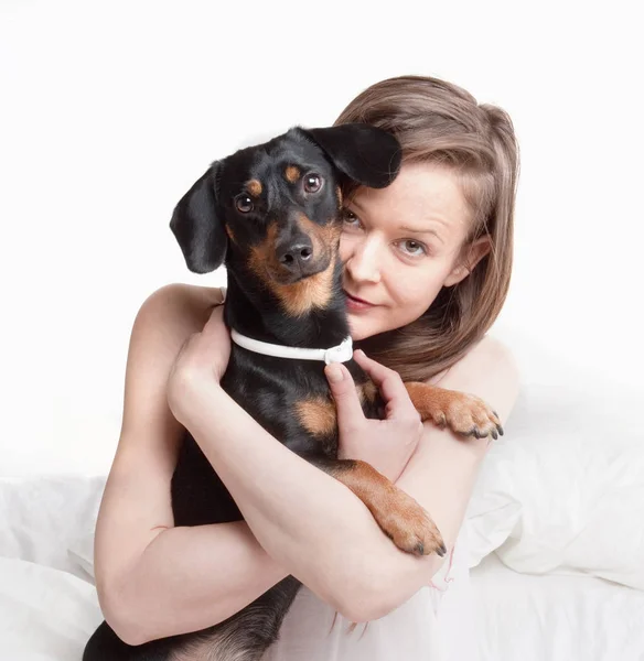 Kvinnan i sängen håller sin hund. — Stockfoto