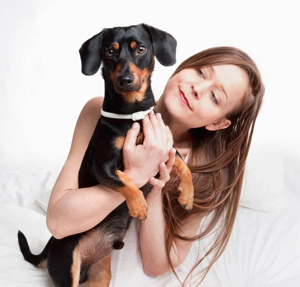 Женщина в постели держит свою собаку . — стоковое фото