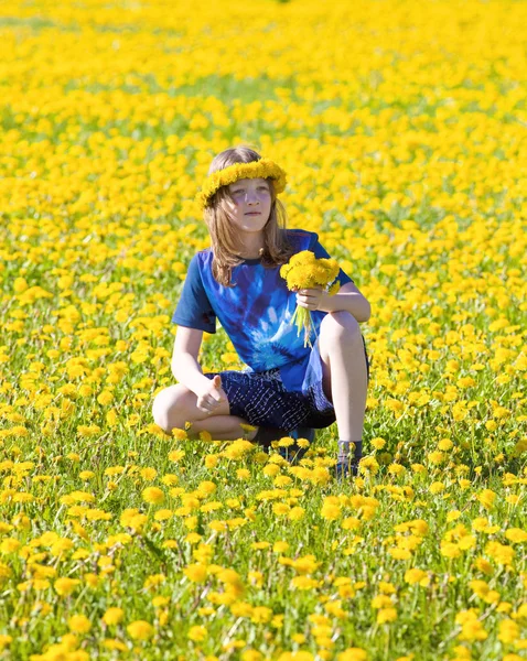 Junge mit blonden Haaren pflückt Löwenzahn auf einer Wiese — Stockfoto