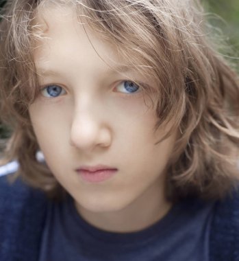 Açık havada kahverengi saçlı bir çocuk portresi.