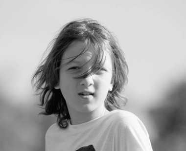 Açık havada kahverengi saçlı bir çocuk portresi.