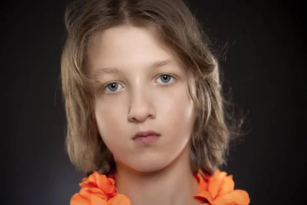 Porträt eines Jungen mit braunen Haaren und Halskettenblume. — Stockfoto