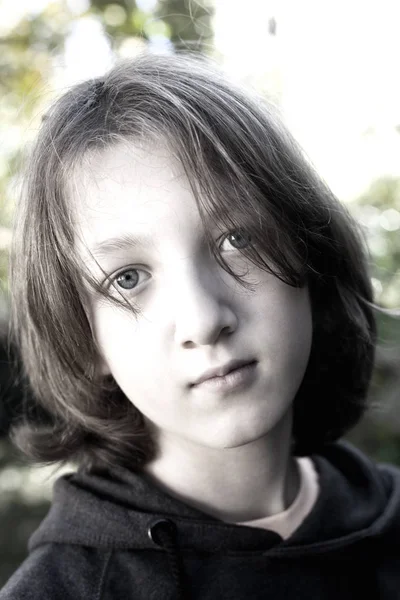 Retrato de um menino com cabelo castanho ao ar livre . — Fotografia de Stock