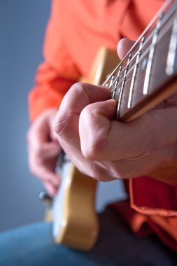 Elektro gitar çalan bir gitaristin parmakları. 