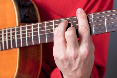 Akustik gitar çalan gitaristin parmakları. 