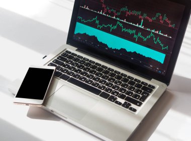 İş üstünde laptop, kopya alanı ile telefon görüntülenen çeşitli göstergeler ile grafik grafikler. Çalışma alanı kavramı